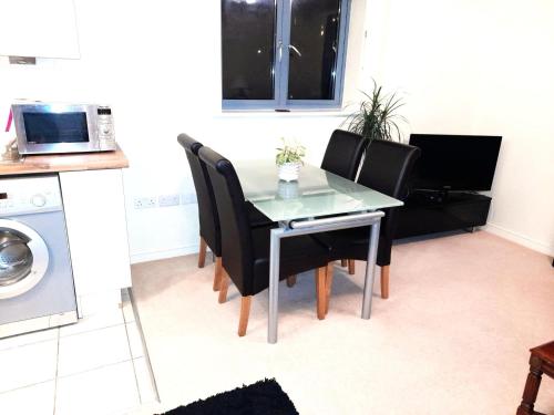 a dining room table with black chairs and a microwave at Oxford Apartment-- Free parking 2 Bedrooms-2Bathrooms-Located in Jericho Oxford close to Bus and Rail station in Oxford