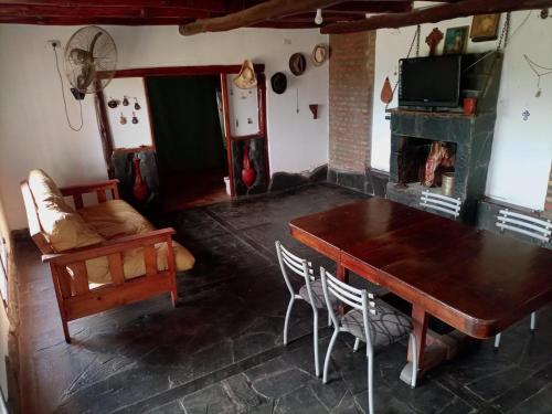 a living room with a wooden table and a fireplace at Casa en Rumipal de 4 a 11 personas in Villa Rumipal