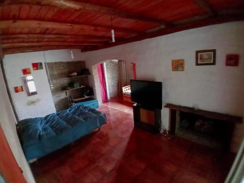 a living room with a blue bed and a fireplace at Casa en Rumipal de 4 a 11 personas in Villa Rumipal