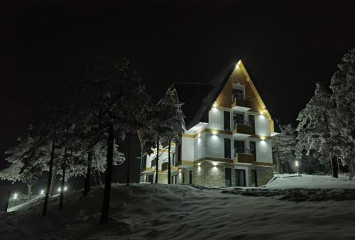 a large white building with lights on it at night at Divčibarski pogledi in Divčibare