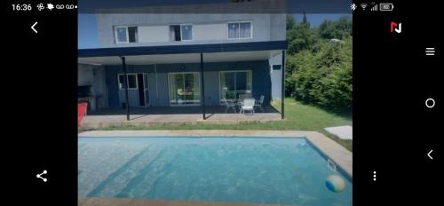 a house with a swimming pool in front of it at Hermosa casa en Lomas Del Rey in San Antonio de Arredondo