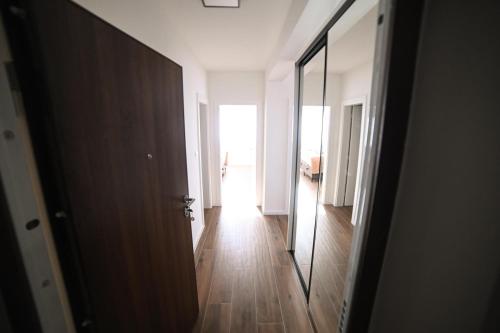 an open door to a hallway with a mirror at Apartman Bašić in Posušje