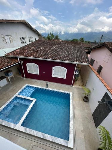 an overhead view of a swimming pool in front of a house at Casa no Centro de Bertioga com Piscina in Bertioga