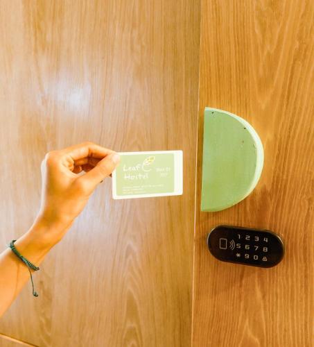a person holding a credit card on a table at Leaf Sustainable Hostel in Da Nang