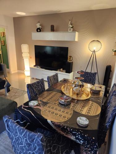 un salon avec une table et une télévision dans l'établissement L'orient de Paris, à Créteil