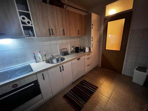 a small kitchen with white cabinets and a sink at Comfort&Peace in Sarajevo