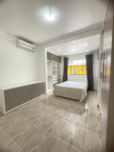 Un dormitorio con una cama y una ventana grande. en Casa piscina com hidromassagem, en Porto Belo