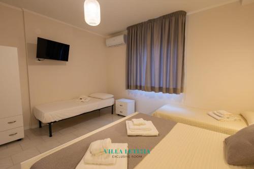 Una pequeña habitación con dos camas y un televisor. en Villa Letizia - luxury Sorrento room, en Boscoreale