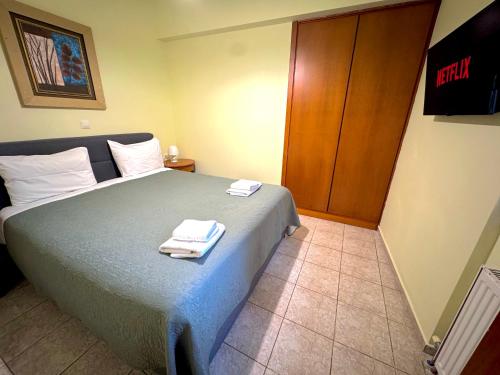 a bedroom with a bed with two towels on it at George Airport Apartments in Heraklio