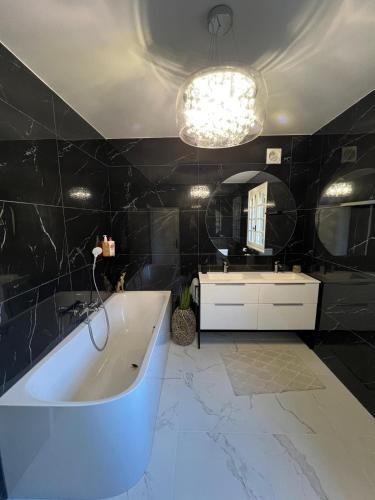 une salle de bain avec une baignoire, un lavabo et un miroir dans l'établissement Très grande maison de caractère - 15 personnes rénovée, à Ussel