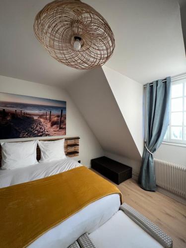 - une chambre avec un lit et un grand lustre dans l'établissement Très grande maison de caractère - 15 personnes rénovée, à Ussel