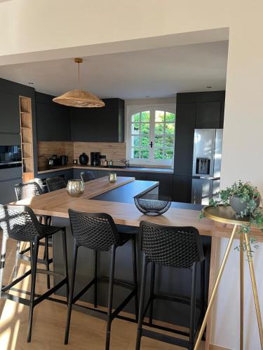 une cuisine avec une grande table et des chaises en bois dans l'établissement Très grande maison de caractère - 15 personnes rénovée, à Ussel