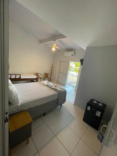 a bedroom with a bed and a table in a room at Pousada e casa Villa Siri in Ubatuba