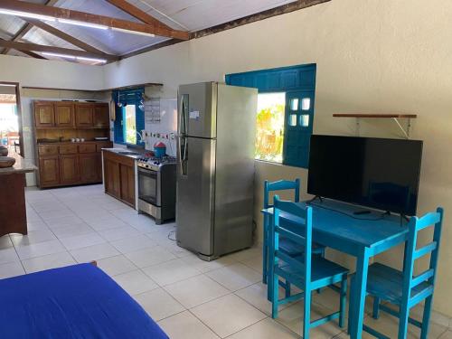 a kitchen with a blue table and a refrigerator at Casa Colorida in Prado