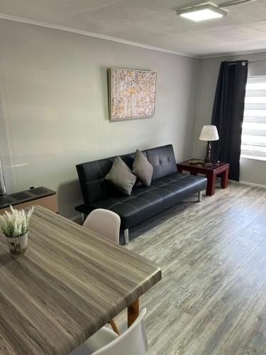 a living room with a black couch and a table at Kau in Punta Arenas