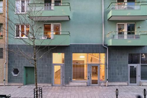 a building with a tree in front of it at The Pink Patio - Cozy Modern Private Apartment in Solna