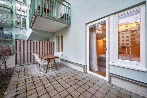 a patio with a table and a balcony at The Pink Patio - Cozy Modern Private Apartment in Solna