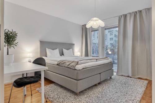a white bedroom with a bed and a desk at The Pink Patio - Cozy Modern Private Apartment in Solna
