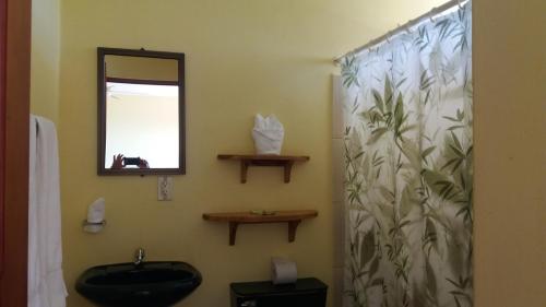 a bathroom with a sink and a toilet and a mirror at La Princesa Hotel in San Isidro