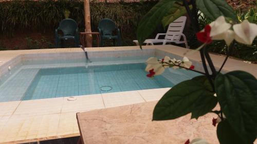 a swimming pool with two chairs and a table and flowers at La Princesa Hotel in San Isidro