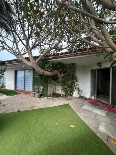 Una casa con un césped verde delante de ella. en La Casona el Encanto, en El Quisco