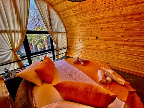 a bedroom with a large bed with pillows and a window at Qafqaz Rolling Bungalow HOT POOL in Gabala