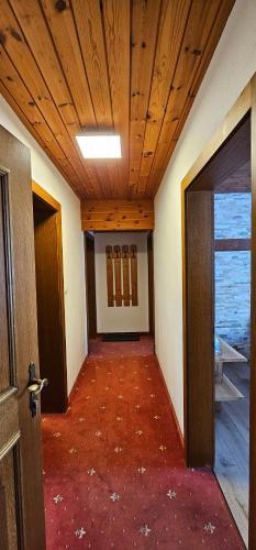 an empty hallway with a wooden ceiling and an open door at Pension Edi in Leutasch