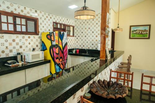 a kitchen with a counter top and a microwave at Recanto Preocupação Zero in Morro Branco