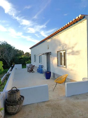 a white house with a patio with a yellow umbrella at Vila Sunrise in Carvoeiro