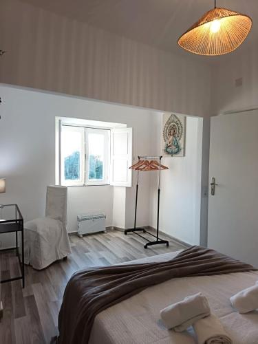 a bedroom with a bed and a lamp and a window at Vila Sunrise in Carvoeiro