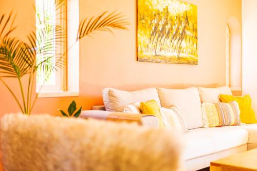 a living room with a white couch with colorful pillows at Casa Brincosa Ericeira in Ericeira
