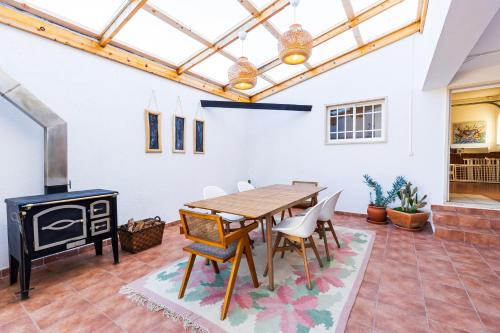 a dining room with a table and a stove at Casa Brincosa Ericeira in Ericeira