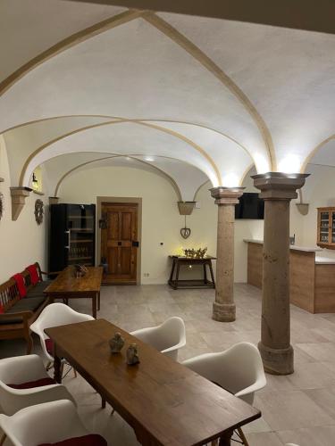 a large room with columns and tables and a kitchen at Karlbacher Domizil Ferienwohnungen in Großkarlbach