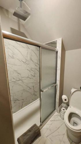 a bathroom with a shower stall and a toilet at ENTIRE 1 BEDROOM APARTMENT ACROSS FROM GOOGLE - br5 in Kitchener