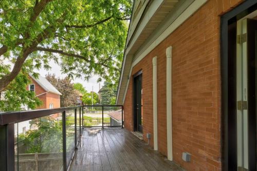 a balcony with a wooden floor and a brick building at ENTIRE 1 BEDROOM APARTMENT ACROSS FROM GOOGLE - br5 in Kitchener