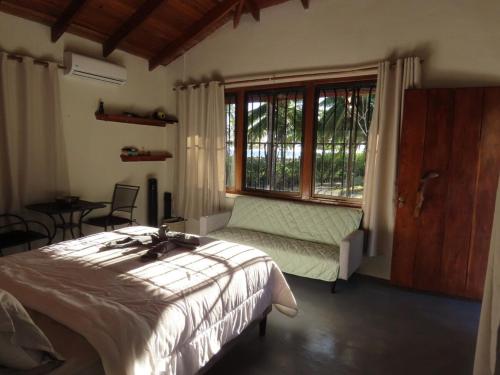 a bedroom with a bed and a large window at Casita Frente al Mar in Cuajiniquil
