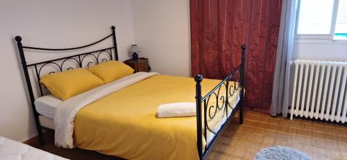 a bedroom with a large bed with yellow pillows at L'Arche de Yves-Jody in Saint-Jean-de-Braye