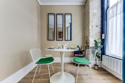 une salle à manger avec une table et deux chaises dans l'établissement Retro Color - Rénové proche de Tour Eiffel, à Paris