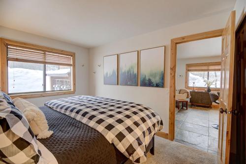 ein Schlafzimmer mit einem Bett mit einer karierten Decke in der Unterkunft Pinetree Retreat - Hot Tub, Heated Pool & Sauna - 6 Min Walk to Lift & Dining in Park City