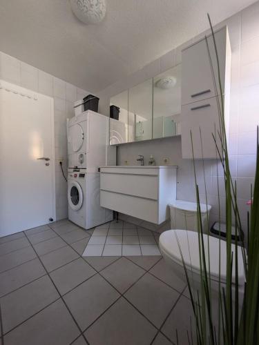 a white kitchen with a sink and a washing machine at Große helle Wohnung nähe Audi und Lidl IT in Bad Friedrichshall