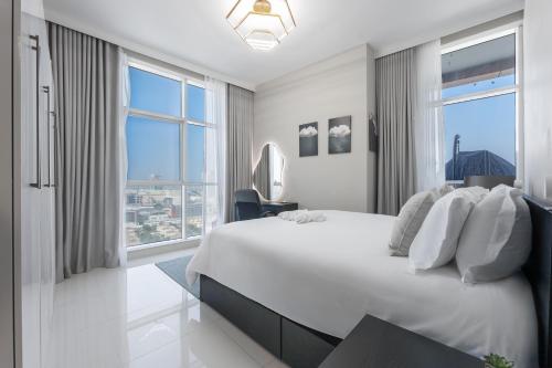 a white bedroom with a large bed and a large window at Great Gatsby's Home in Dubai