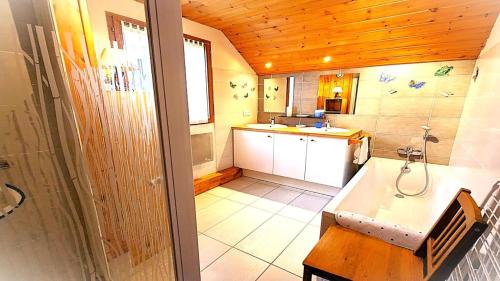 une salle de bain avec une baignoire et un lavabo dans une pièce dans l'établissement Chalet Meijoun-pelvoux - Chalet de montagne confortable pour 10 personnes MAE-6831, à Pelvoux