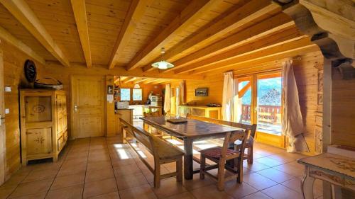 une salle à manger avec une table et des chaises dans une cabine dans l'établissement Chalet Pierre-puy-saint-vincent 1400 - Magnifique Chalet de 12 couchages proche des pistes MAE-6891, à Puy-Saint-Vincent