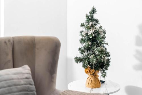 a small christmas tree on a table next to a chair at Harmony House 3 Bedroom New Build for Families, Contractors, Black Country Museum Sleeps 6 in Tipton