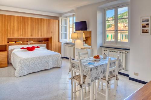 a bedroom with a bed and a table with chairs at Studio Paola - Levanto in Levanto