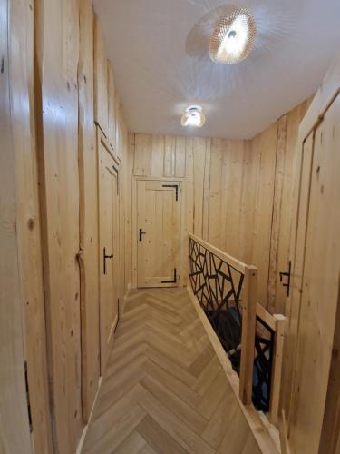 a hallway with wooden walls and a staircase in a house at Chata Braci Warchały in Warchały
