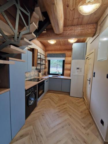 a kitchen with white appliances and wooden ceilings at Chata Braci Warchały in Warchały