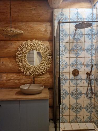 a bathroom with a mirror on a wooden wall at Chata Braci Warchały in Warchały