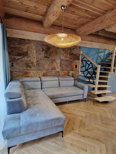 a living room with a couch and a chandelier at Chata Braci Warchały in Warchały