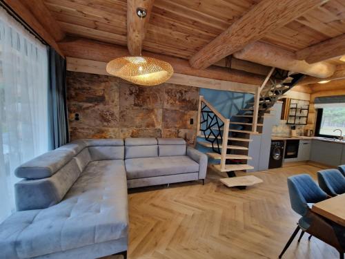 a living room with a couch and a staircase at Chata Braci Warchały in Warchały